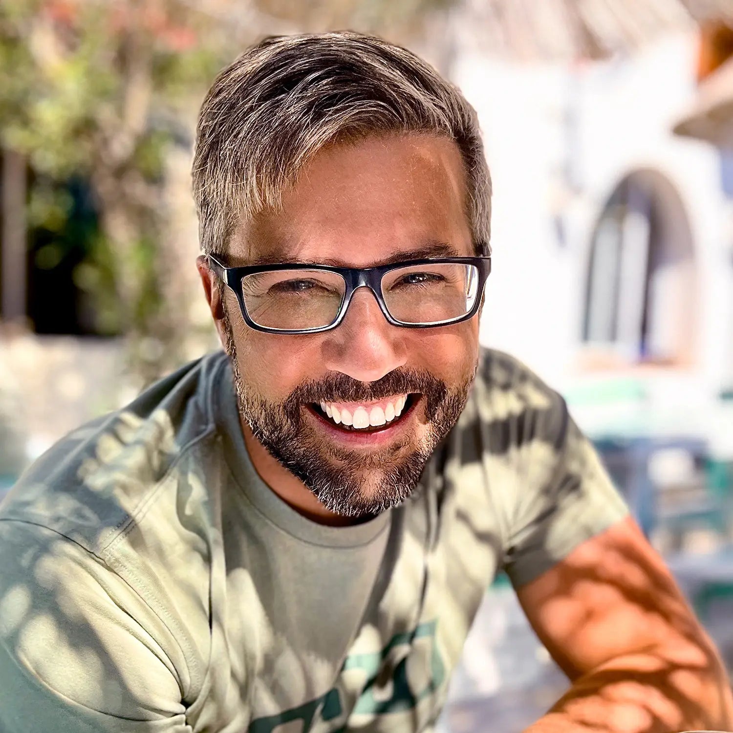 Frank mit Brille und Bart lächelt im Freien